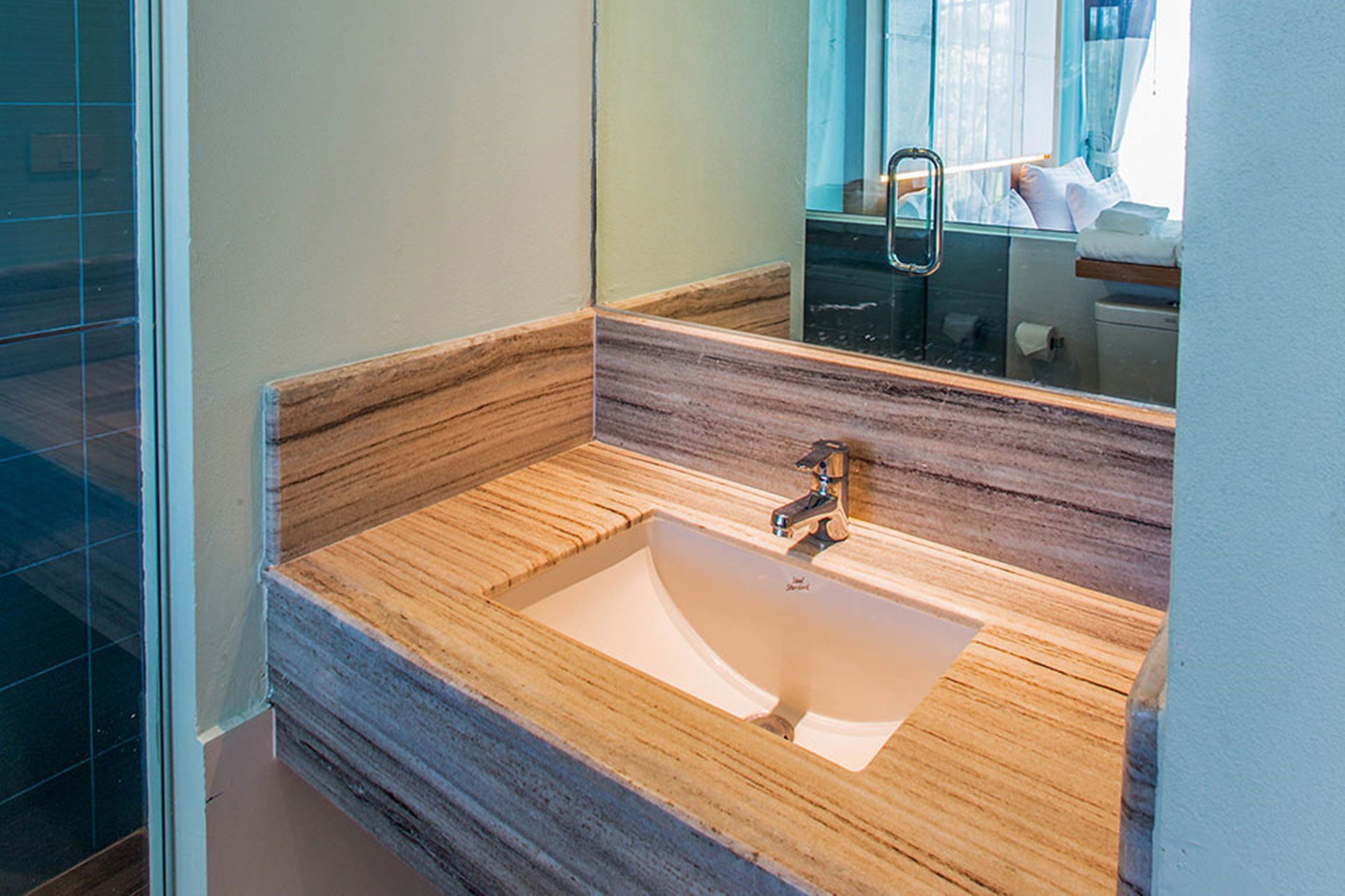 A bathroom with a wooden vanity, a sink, and a mirror.
