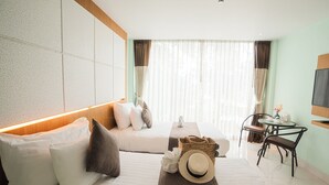 Una habitación de hotel moderna con cama, sofá, zona de comedor y televisión.