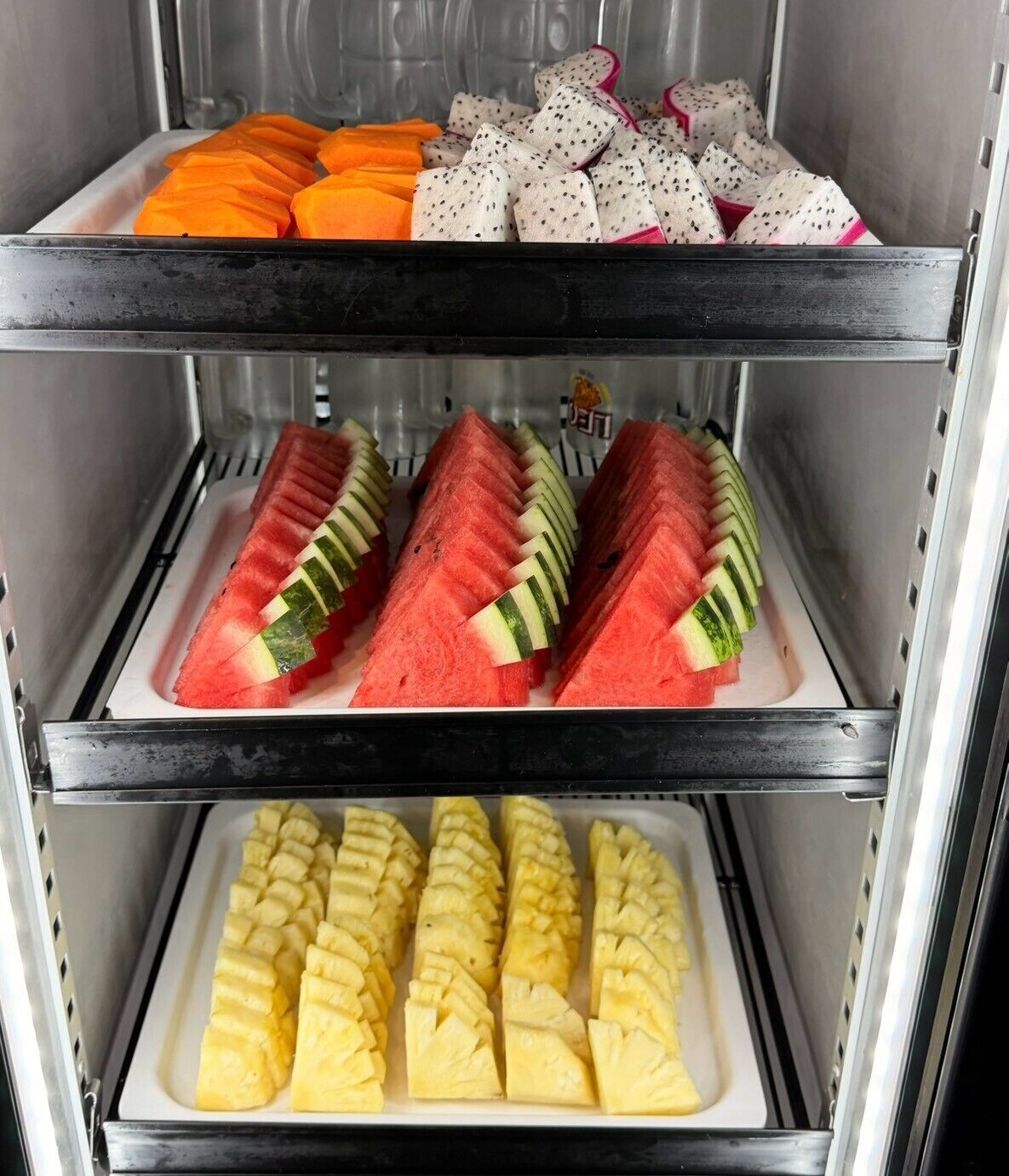 Mostrador refrigerado con diversas frutas.