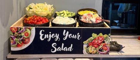 A salad bar with various fresh vegetables and salad options.