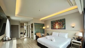 A modern hotel room with a large bed, a desk, a chair, and a painting on the wall. - Le Naview @Prasingh (Chiang Mai)