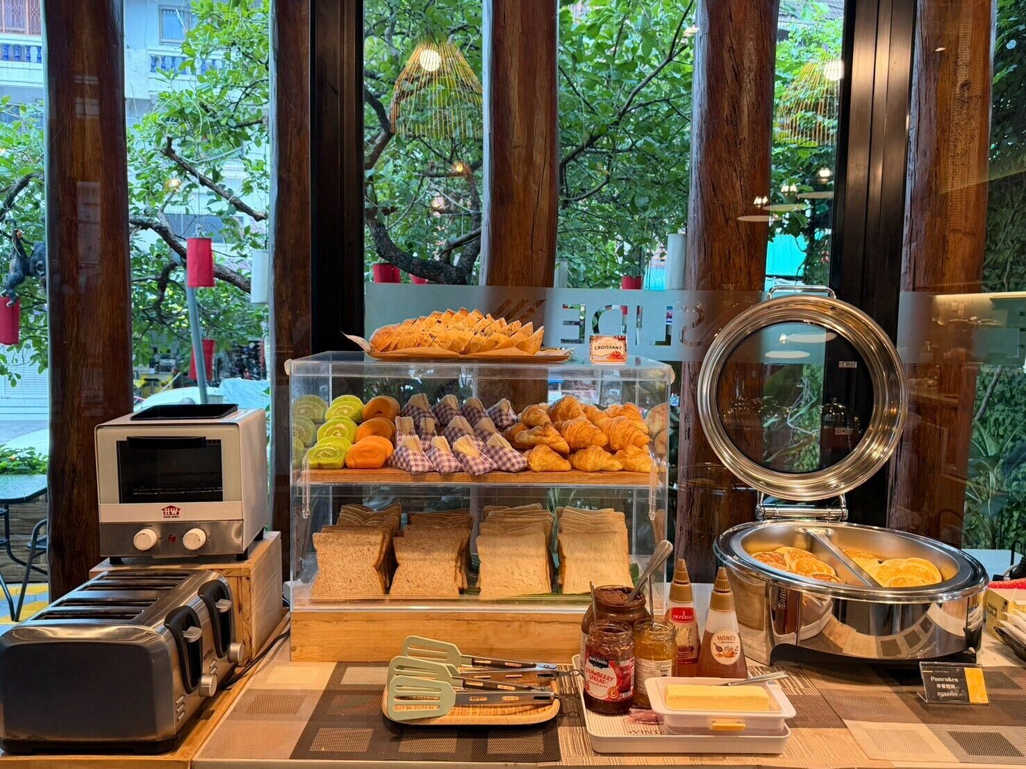A breakfast buffet with various pastries, bread, and spreads.
