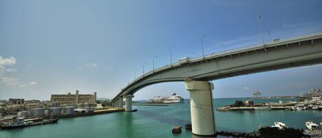 A bridge over a body of water with boats docked nearby.