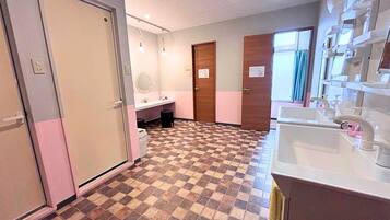 Un baño de hotel con piso a cuadros, un lavamanos, un espejo y una puerta.
