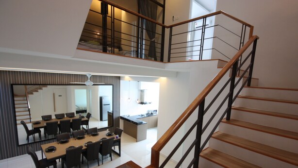 Un interior moderno con comedor, cocina y escalera.