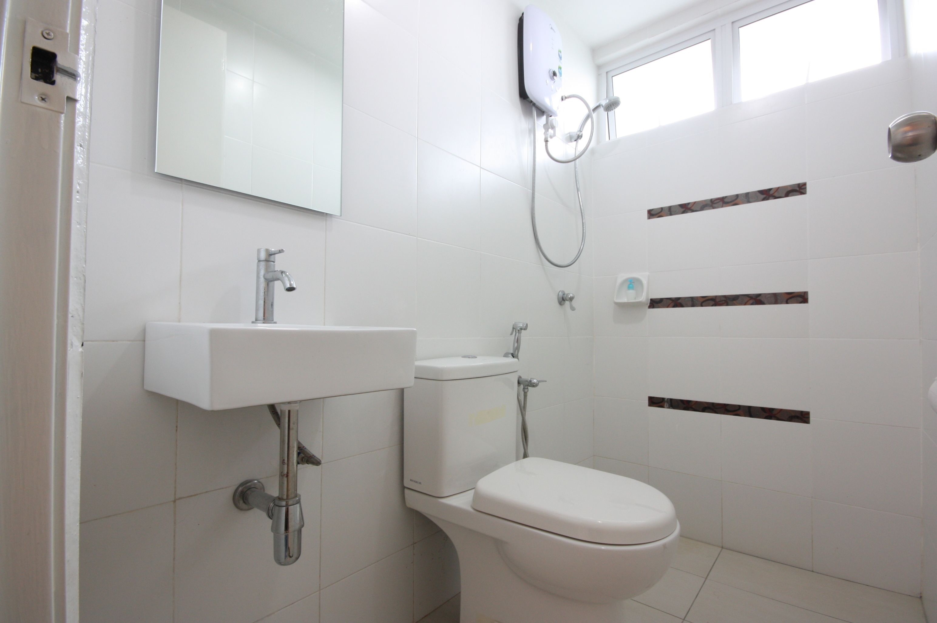 Baño con lavamanos, inodoro y ducha blancos.