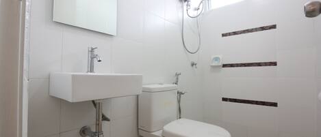 Baño con lavamanos, inodoro y ducha blancos.
