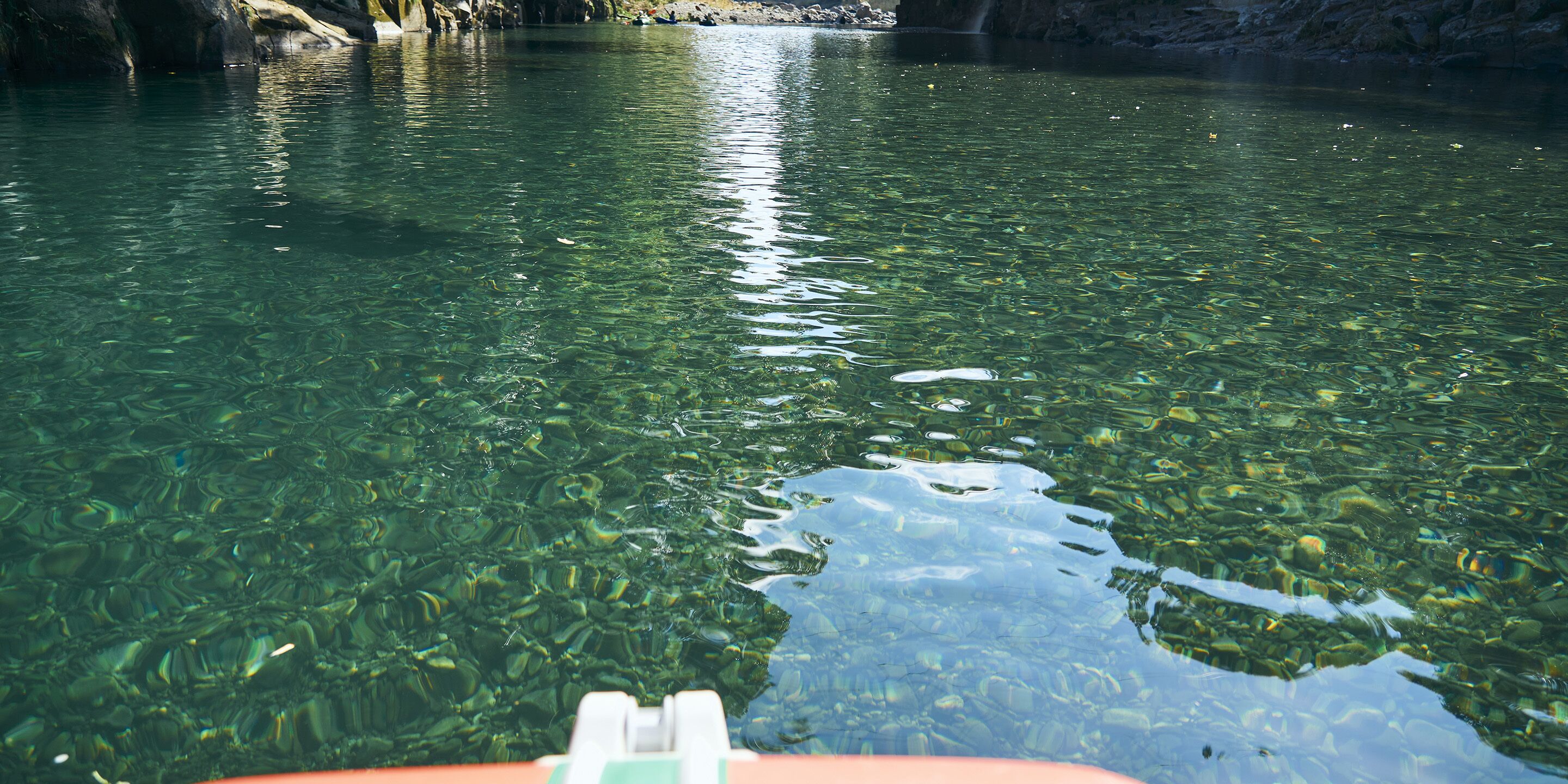 A clear view of a river with visible rocks and water.