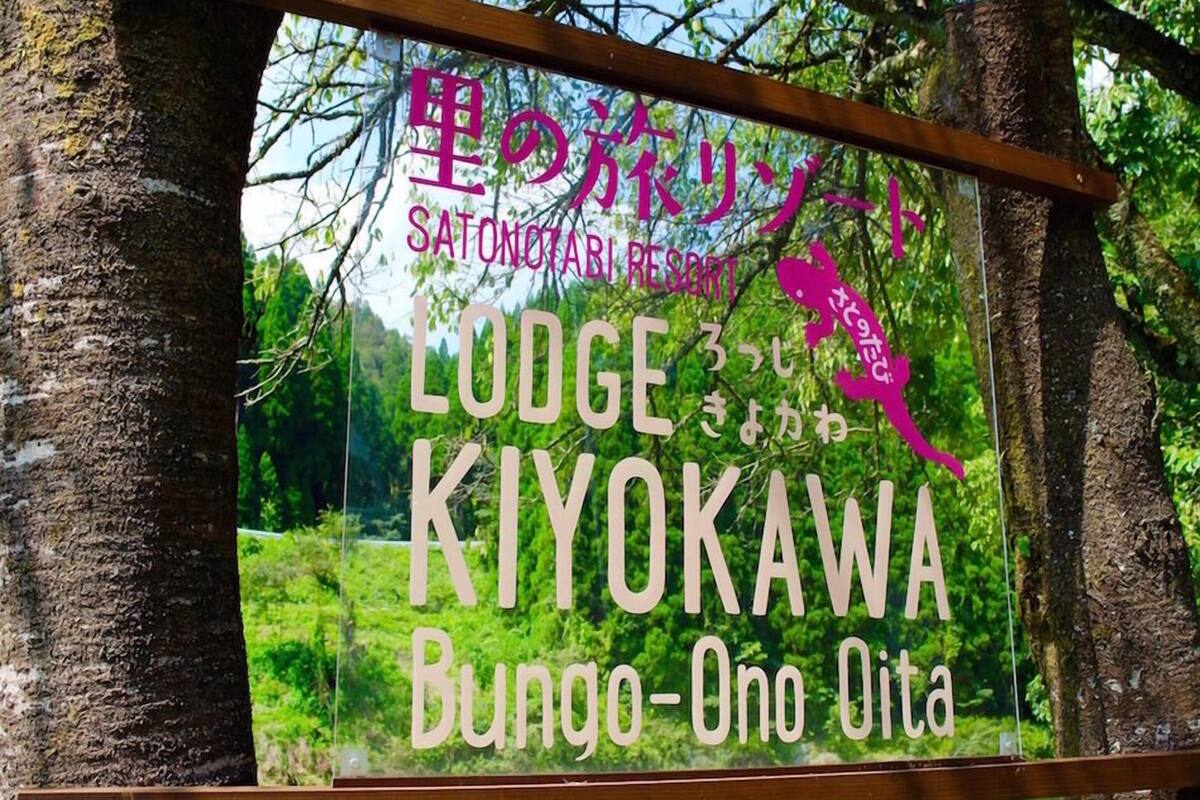 Une enseigne pour le LODGE KIYOKAWA, situé à Bungo-ono, dans la préfecture d'Oita, avec du texte en japonais et la silhouette d'une personne.