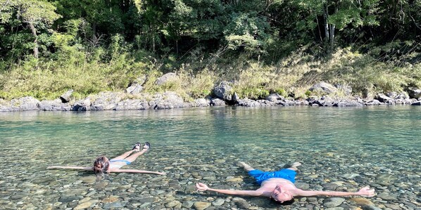 Deux personnes allongées sur le lit rocheux d’une rivière.