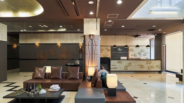 A modern lobby with a seating area, a reception desk, and a large pillar. - HOTEL GLOBAL VIEW SAPPORO (Sapporo)