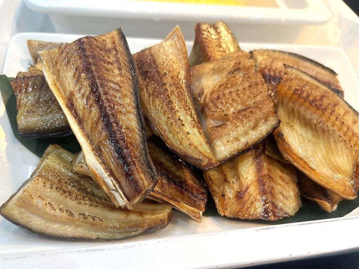 A white plate with roasted eggplant slices.