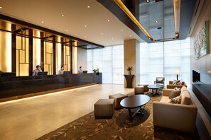 A modern hotel lobby with a reception desk, seating area, and large windows. - LOTTE CITY HOTEL MYEONGDONG (Seoul)