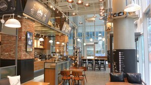 A coffee shop interior with brick walls, wooden tables, and hanging pendant lights. - LOTTE CITY HOTEL MYEONGDONG (Seoul)