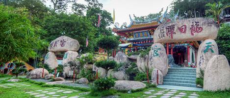 A traditional Chinese temple with large rocks and a colorful roof.