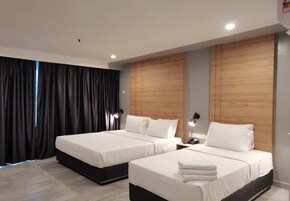 A modern hotel room with two beds, a wooden headboard, a bedside table with a lamp, and a large window with curtains.