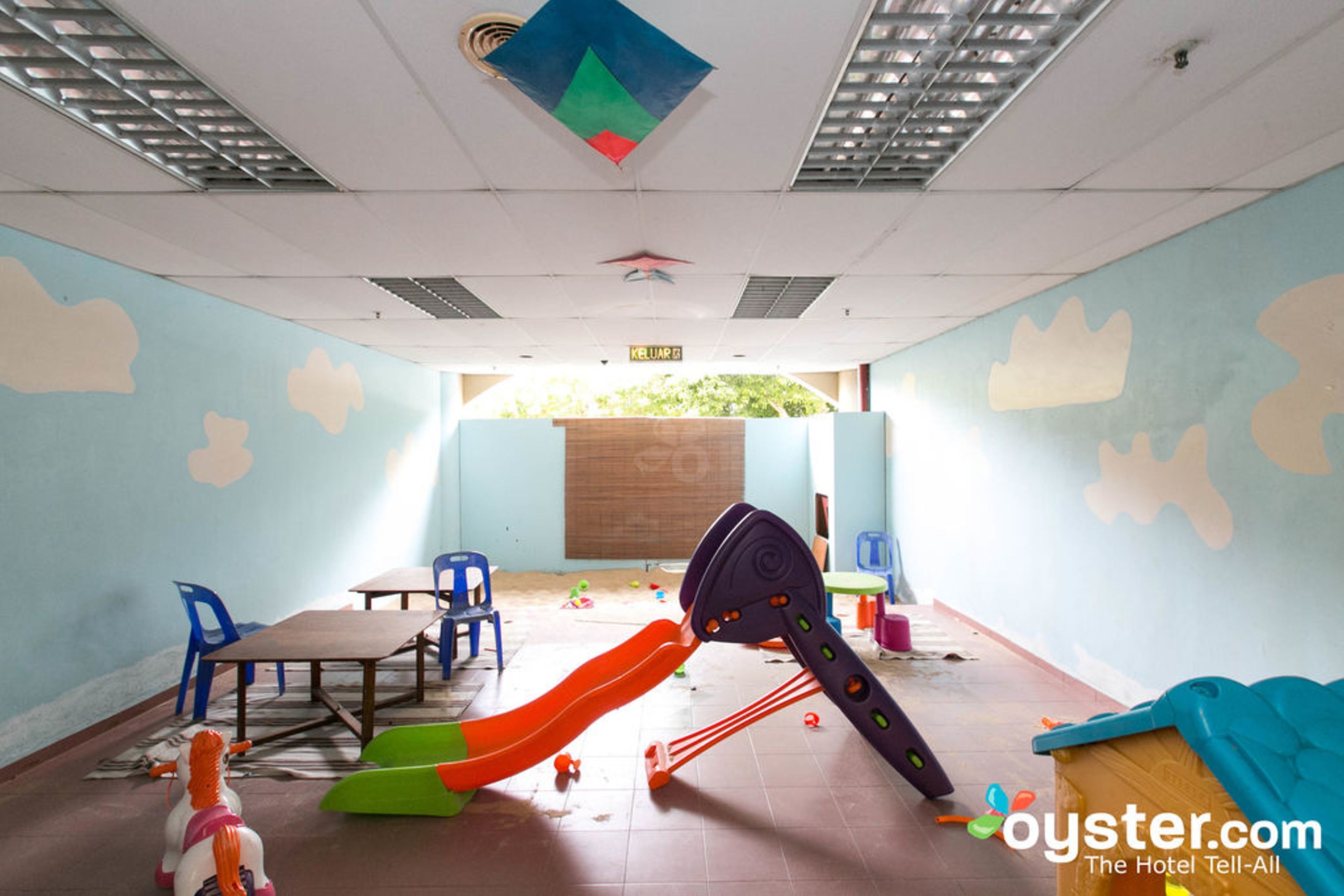 A children's play area with a slide, tables, chairs, and a wooden play structure.
