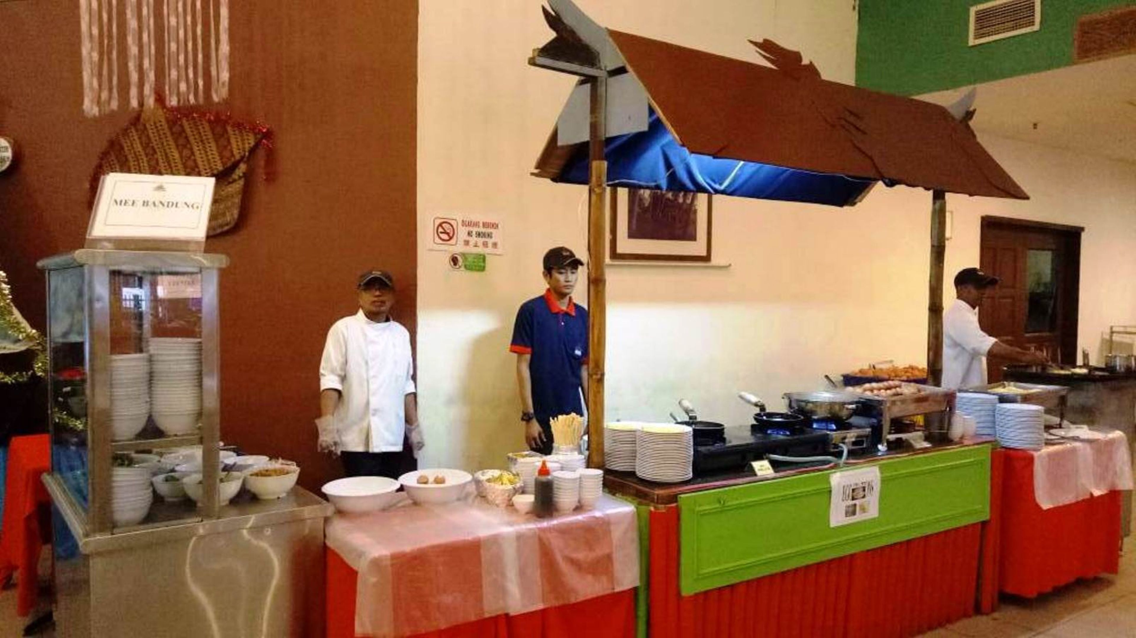 A buffet setup with food items and serving staff.