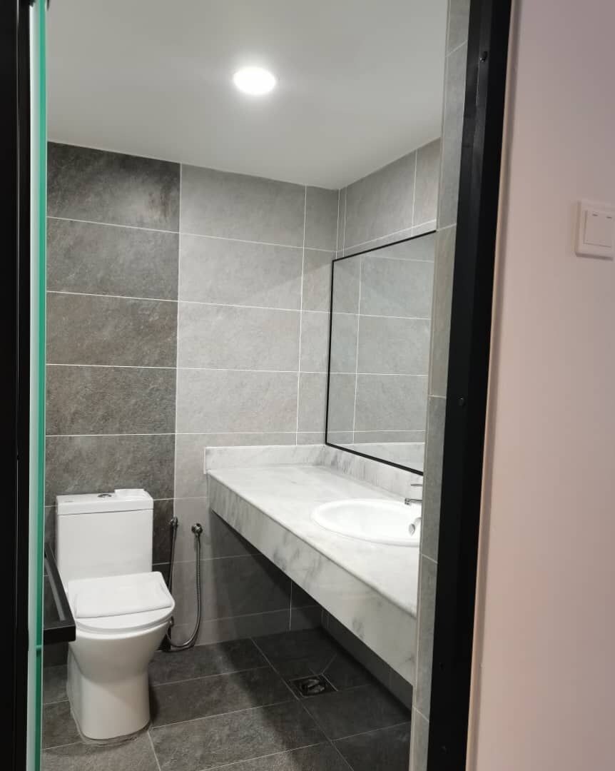 A modern bathroom with a toilet, sink, and shower.