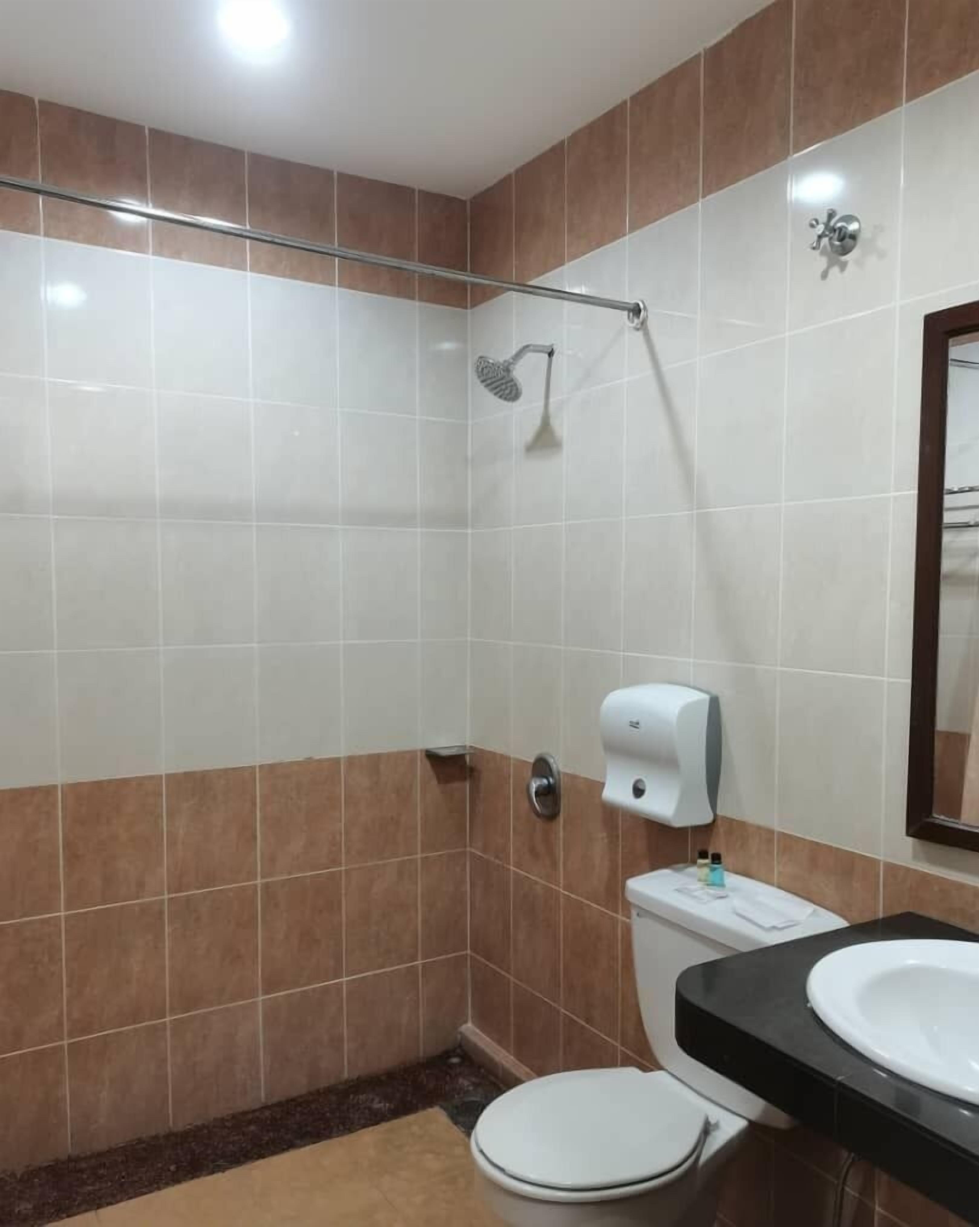 Ein Badezimmer mit Dusche, Toilette und Waschbecken.