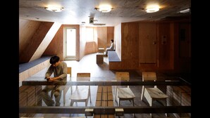 A modern interior with wooden walls, a glass table, and several chairs. - ℃ (Do-C) Gotanda (Tokyo)