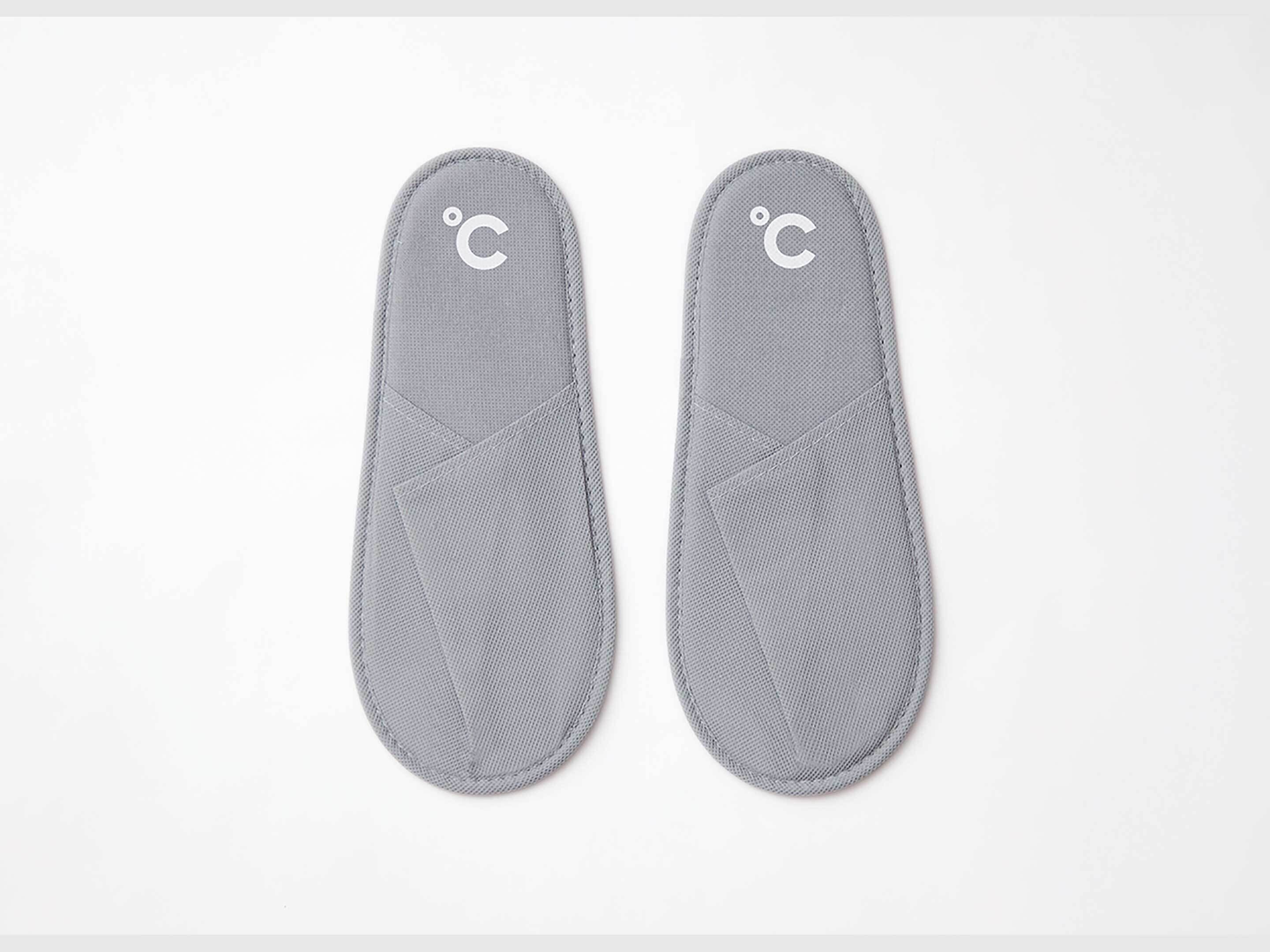 A pair of gray thermal insoles with a temperature indicator.