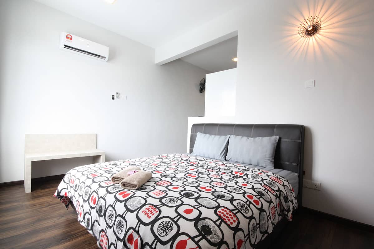 A modern bedroom with a large bed, a bench, and a ceiling light fixture.
