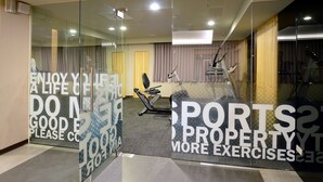 Een sportschool met trainingsapparatuur en motiverende tekst op de muur.