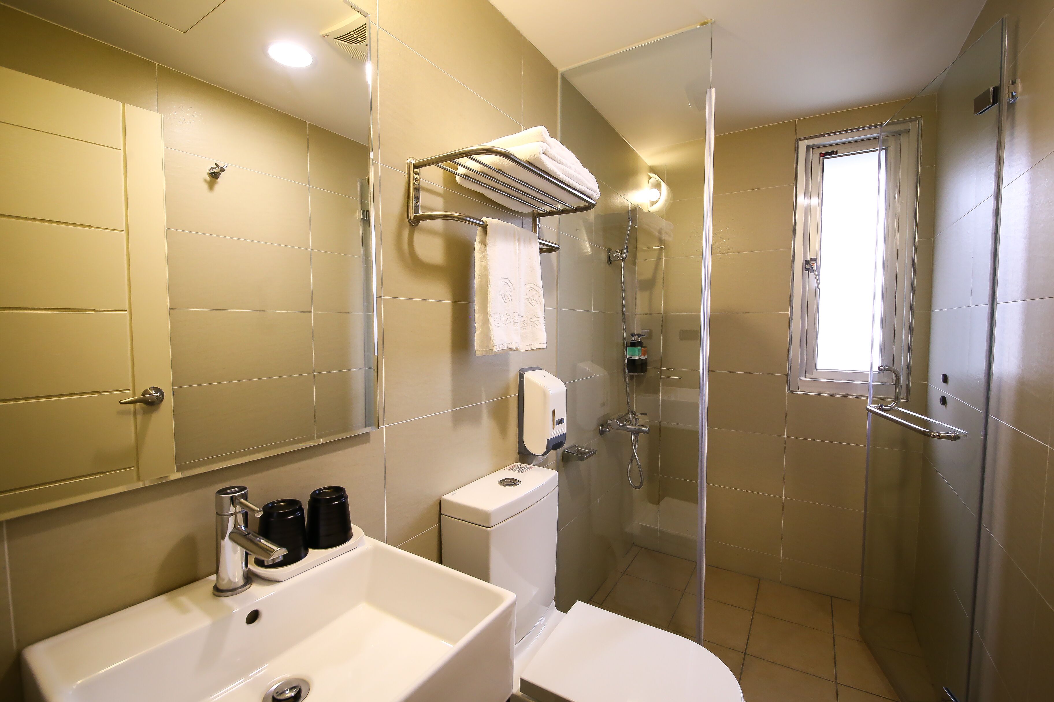 Un baño moderno con lavamanos, inodoro y ducha.