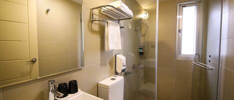 Un baño moderno con lavamanos, inodoro y ducha.