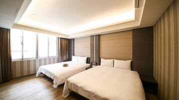 A hotel room with two beds, a large window, and a modern ceiling design.
