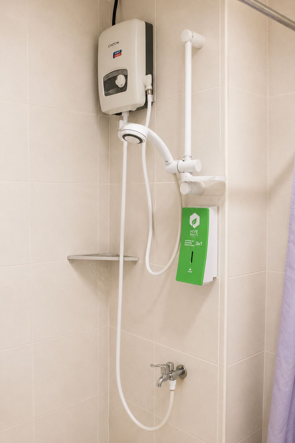 Une douche dotée d’un panneau de commande, d’un pommeau de douche à main et d’un flexible de douche à main.