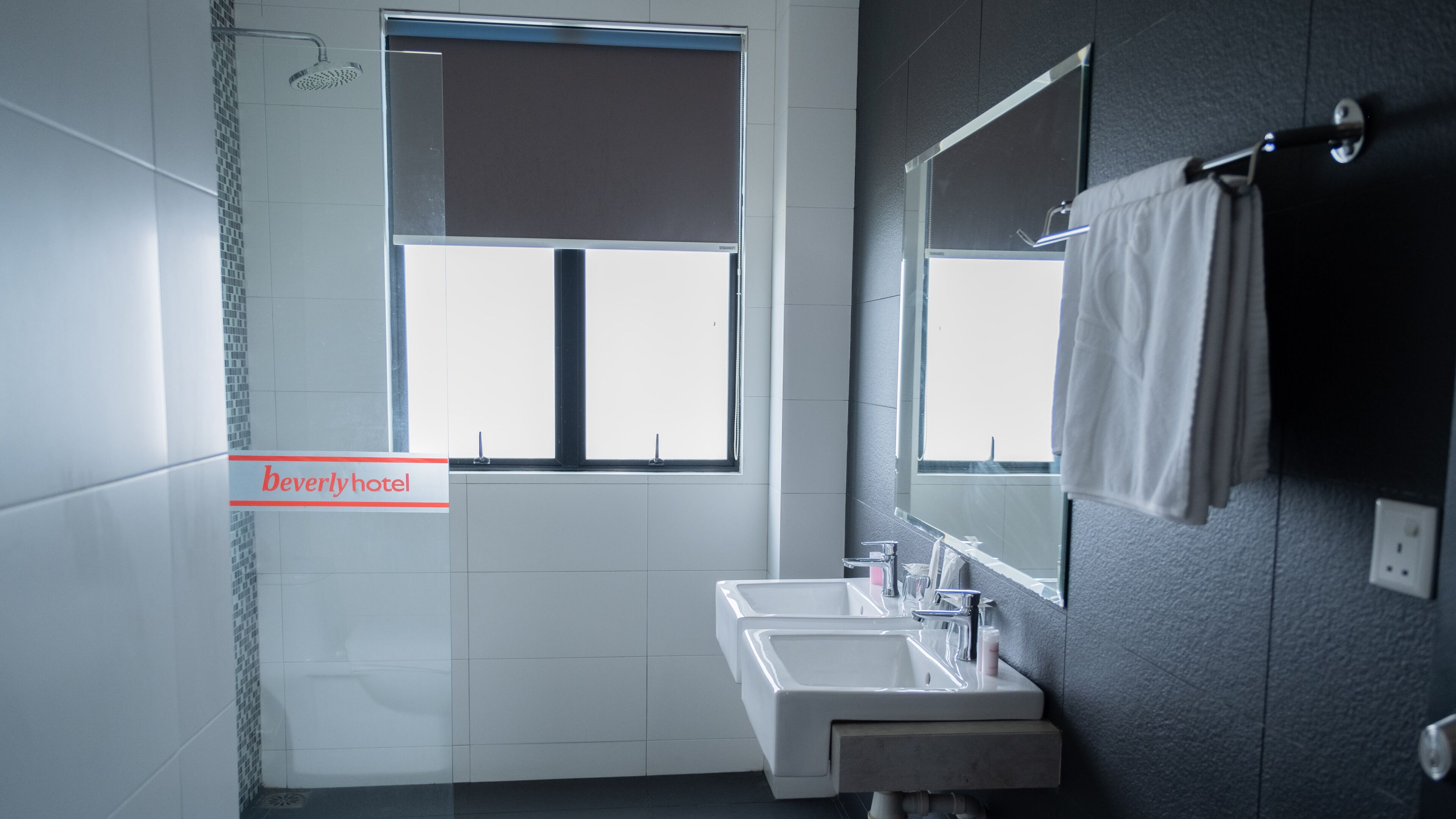 Un baño con ventana, lavabo y espejo.