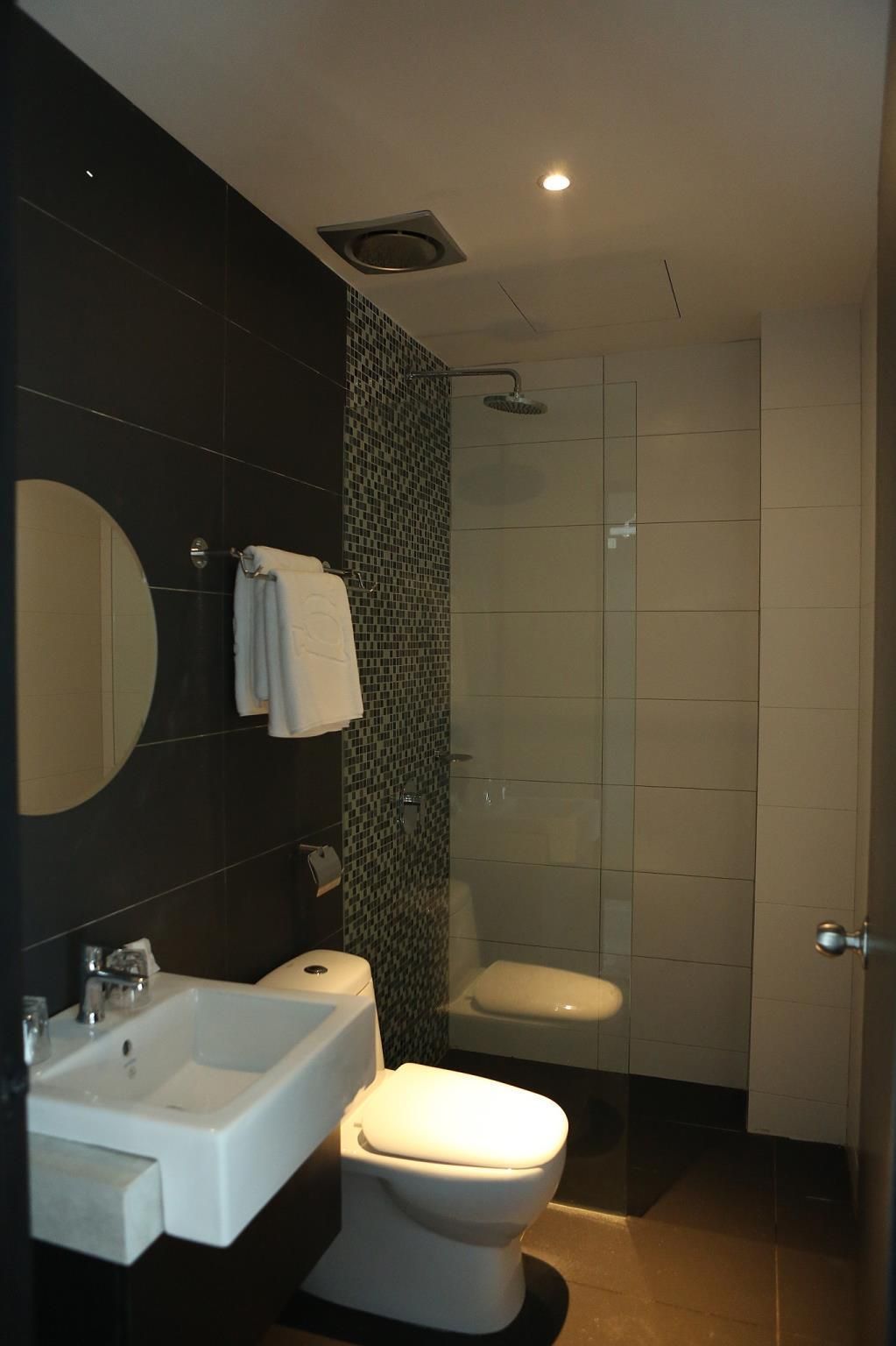 Un baño moderno con lavamanos, inodoro y ducha.