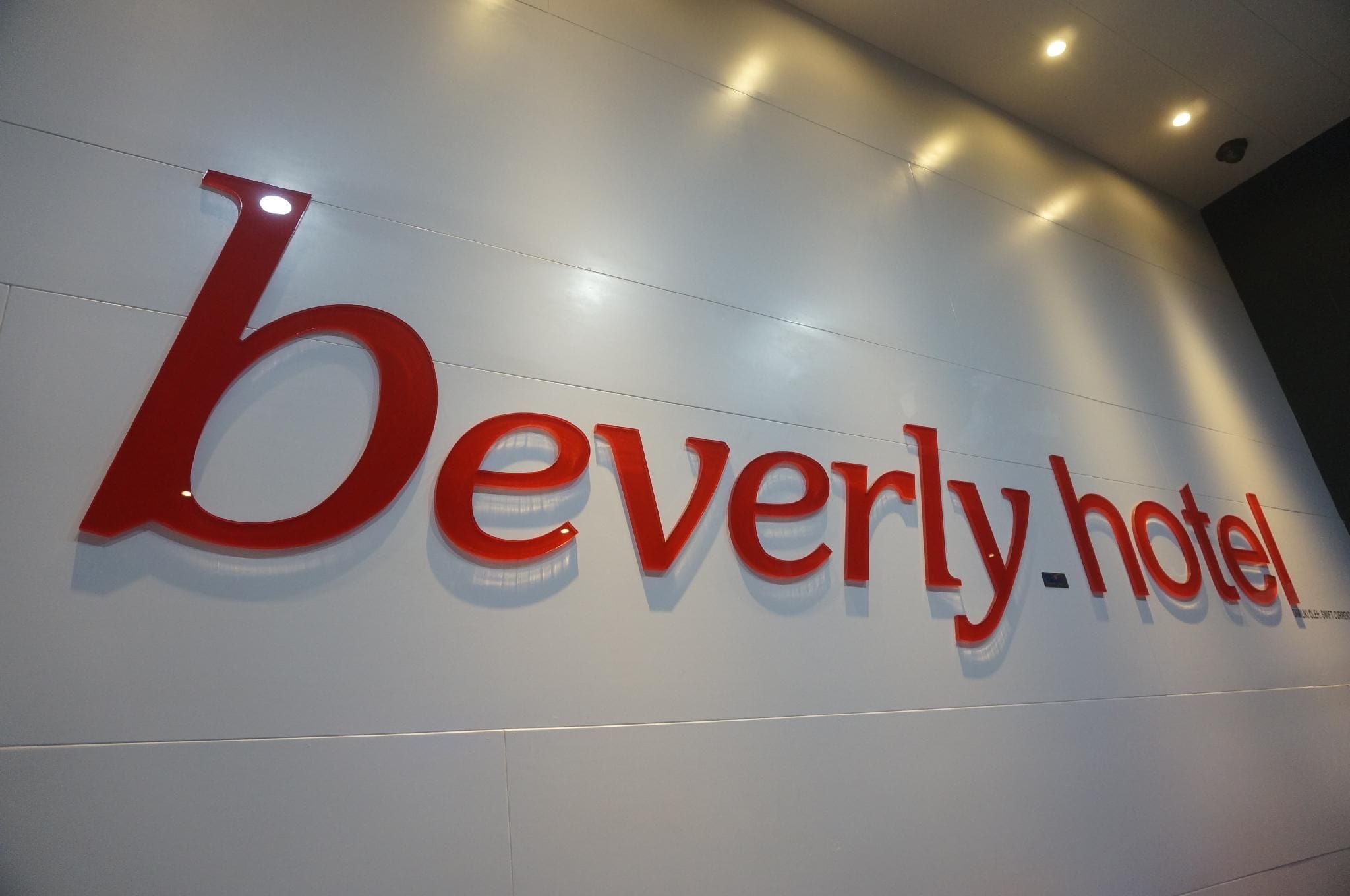 Een hotelschiltje met de naam 'beverly hotel' in grote, rode letters.