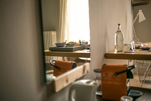 Work in comfort with a dedicated desk and chair, a refreshing water bottle, and a touch of greenery.
