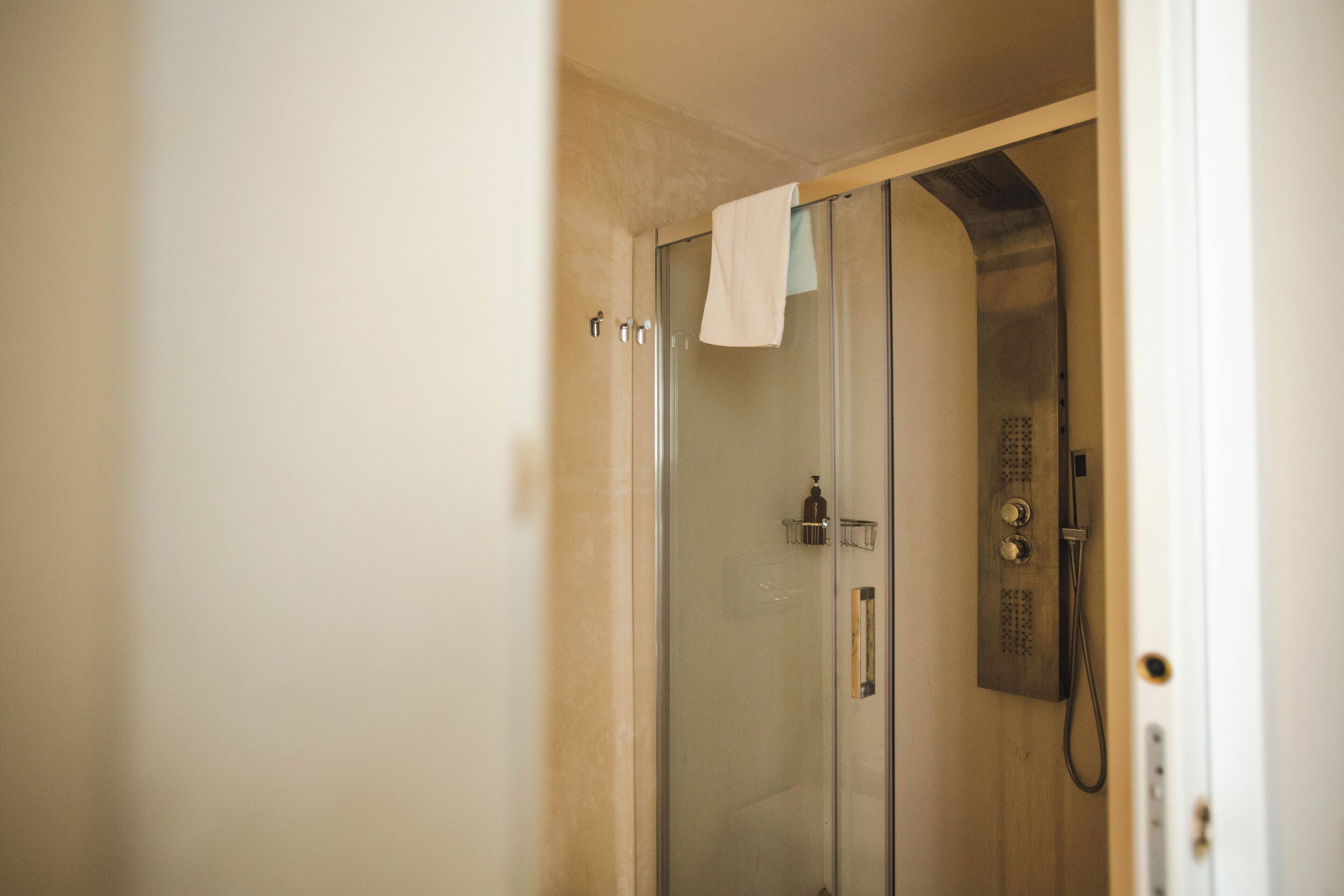 A glass-enclosed shower stall with a towel hanging on the door handle.