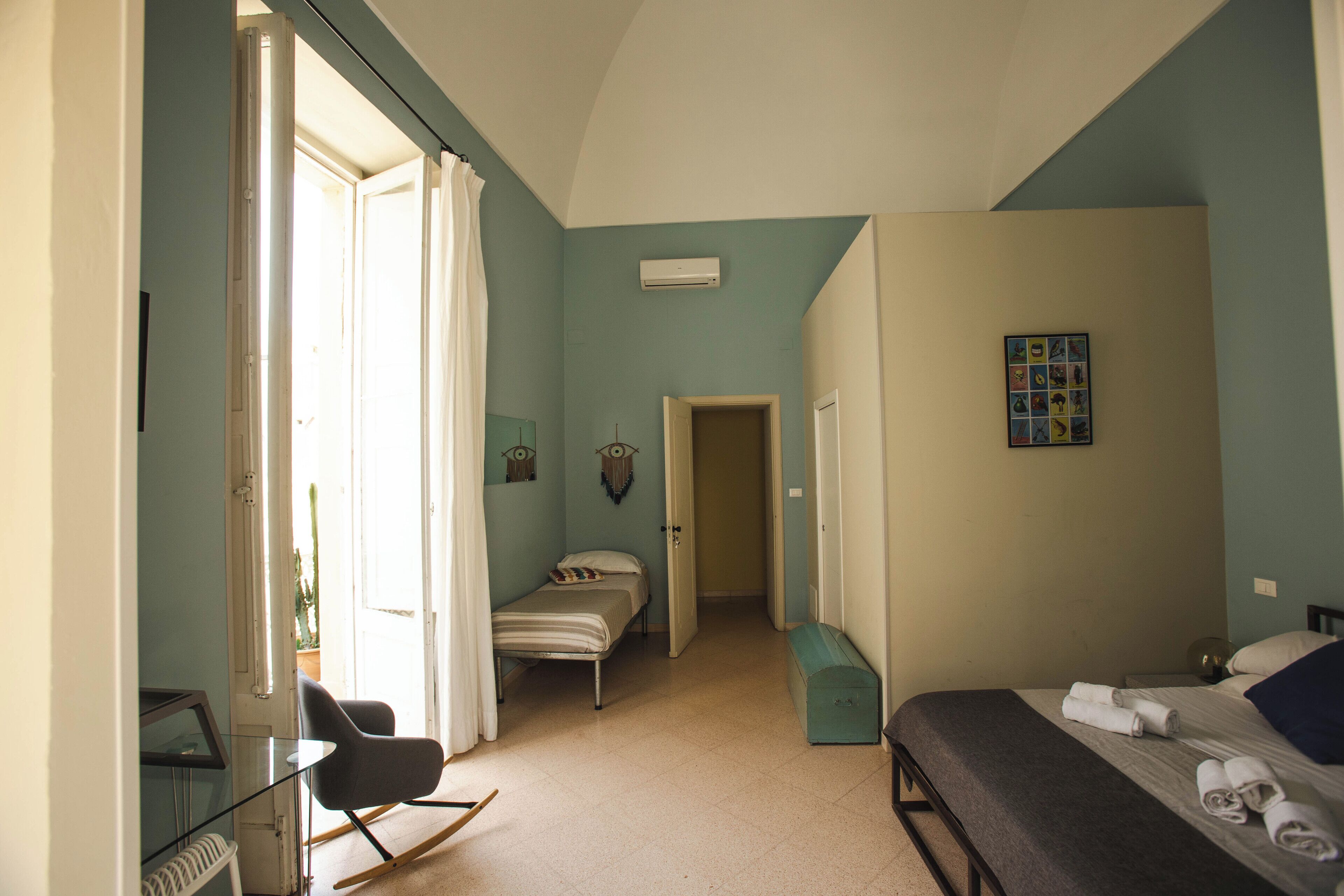 A bedroom with a bed, a desk, a chair, and a bench.