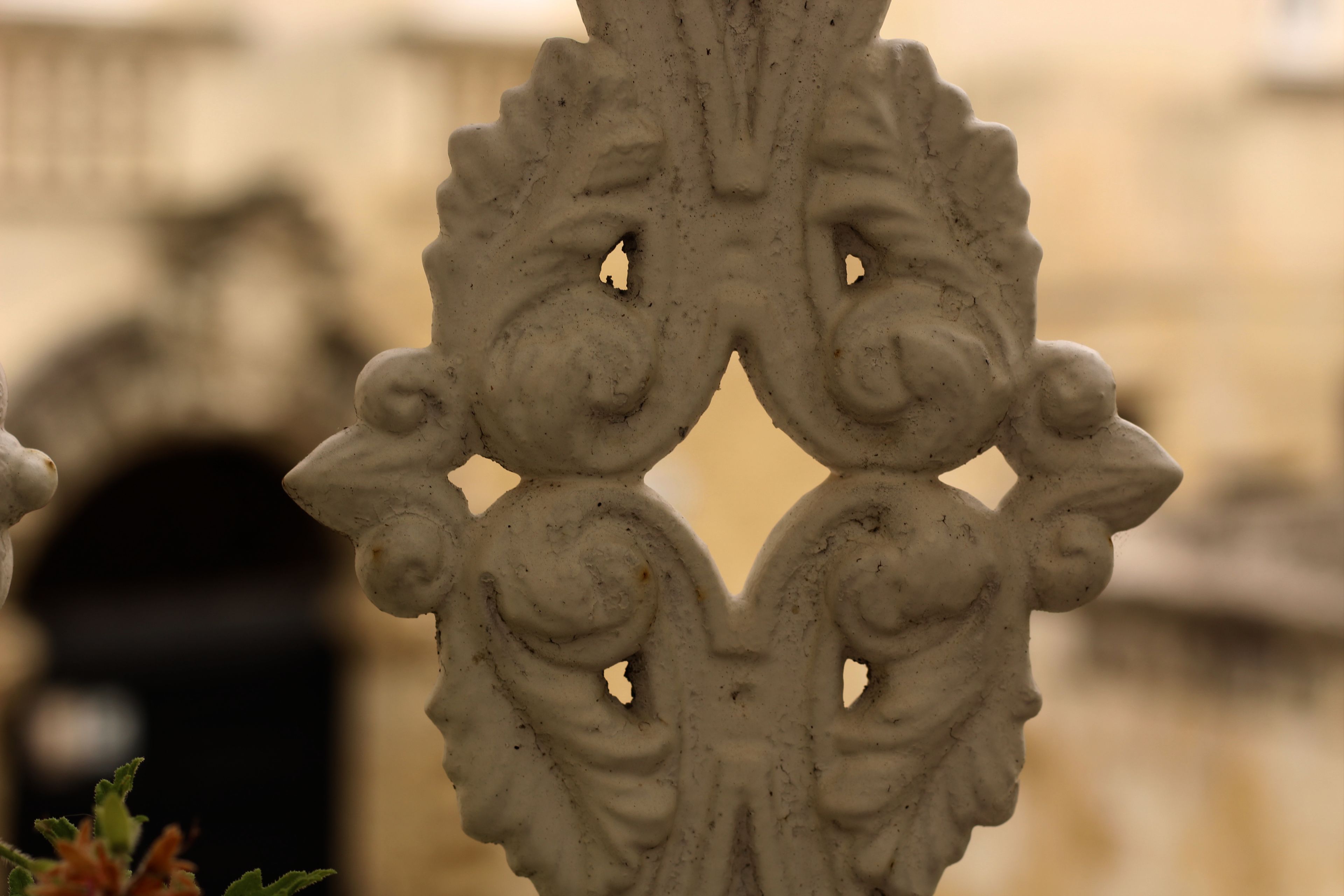 A close-up of an ornate metal gate with intricate designs and cut-out patterns.