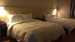 A hotel room with two beds, each with white linens and headboards. There are bedside lamps and a nightstand with a lamp. - Long Siang Hotel (Kaohsiung)