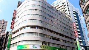 A multi-story building with a curved facade, featuring a prominent Sunny Bank sign at the ground level. - Long Siang Hotel (Kaohsiung)