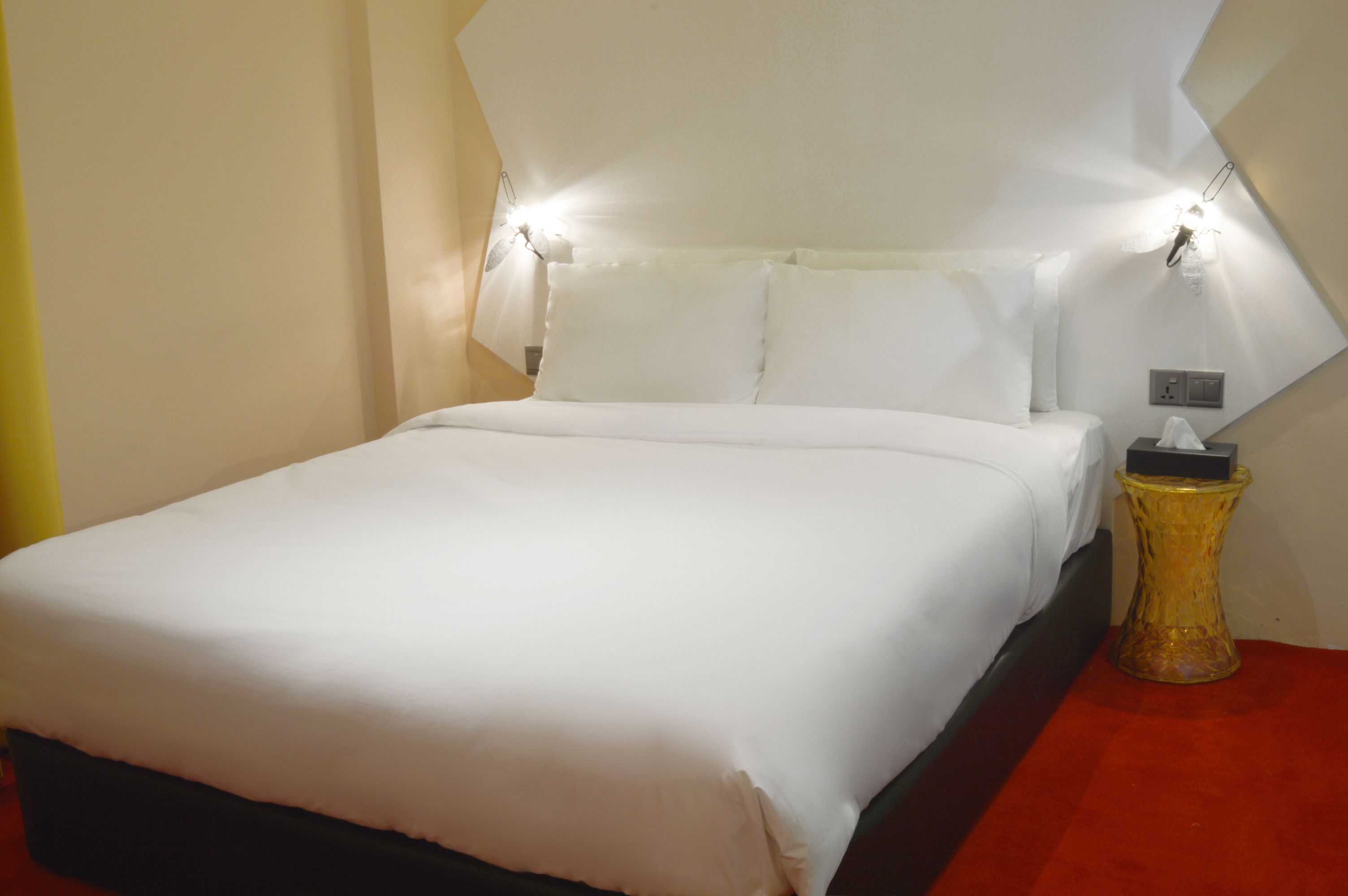 A neatly made bed with white linens in a hotel room.