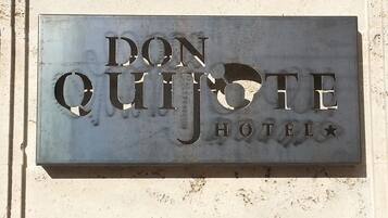 A metal sign for Don Quijote Hotel with a star symbol.