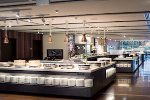 A buffet setup with multiple serving stations, a variety of dishes, and a modern interior design.