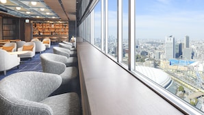 A modern hotel lobby with seating areas and a city view. - Tokyo Dome Hotel (Tokyo)