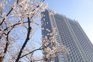 A high-rise building with a modern glass facade and a clear blue sky in the background.