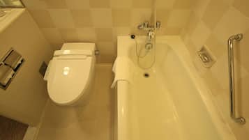 A bathroom with a toilet, a bathtub, and a handrail.