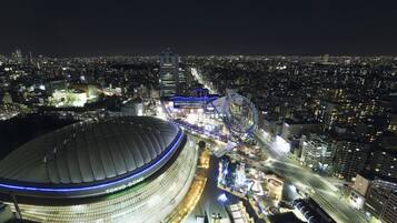 A nighttime view of Tokyo Dome with surrounding city lights and infrastructure.