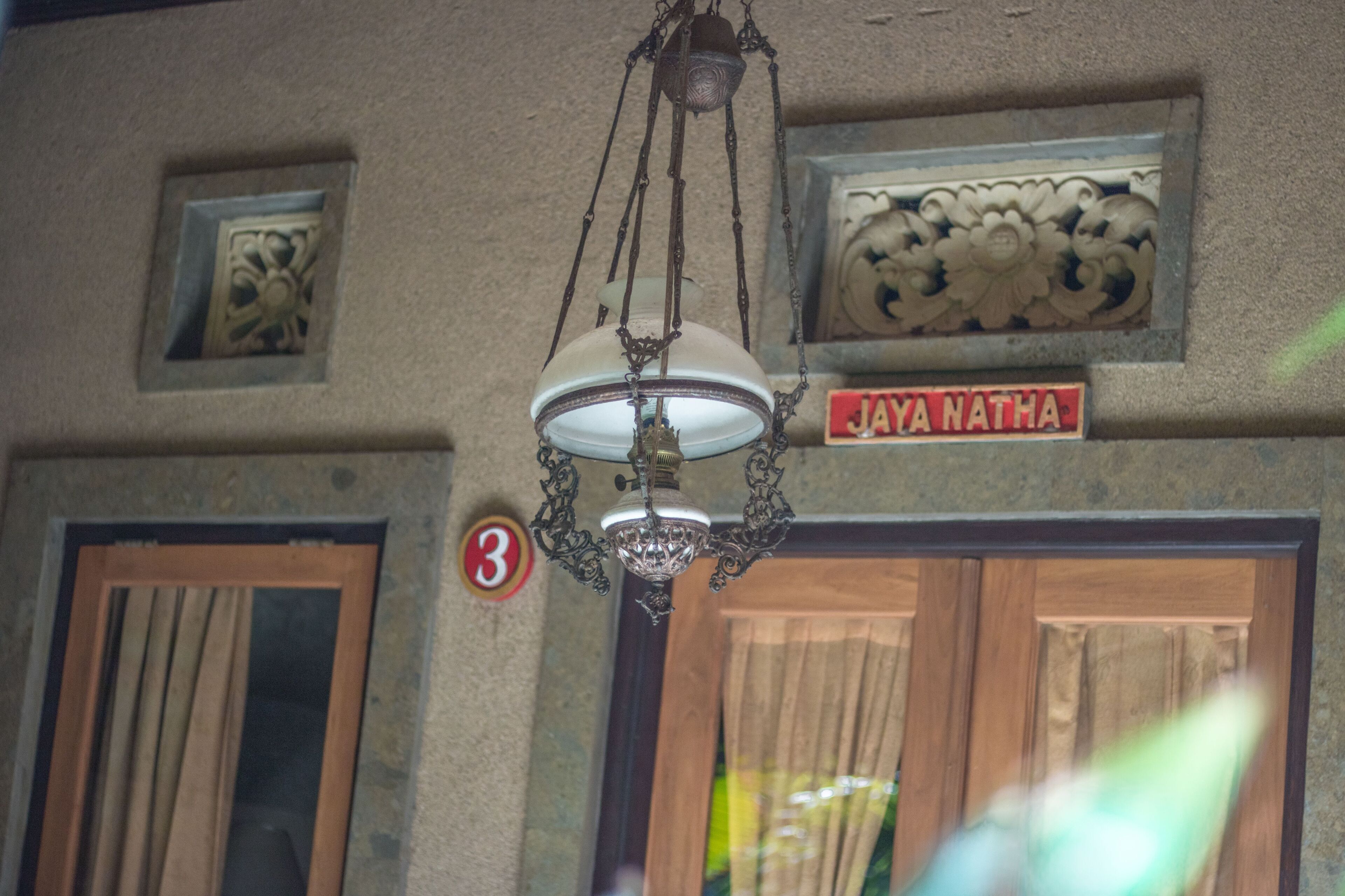 A room with a chandelier, a door with a number sign, and a sign above the door.