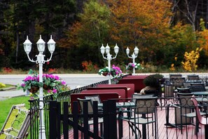 Outdoor seating with tables and chairs, surrounded by a fence and decorative street lamps. - The Mountain View Motel & Cottages (Pleasant Bay)
